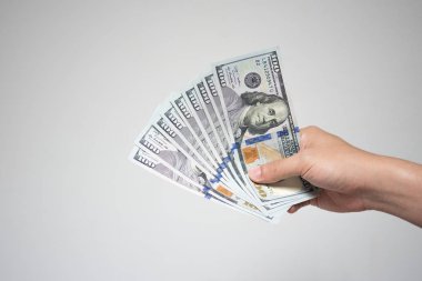 Bize dolar faturaları para beyaz arka plan üzerinde elinde. Holding ya da birçok yüz dolarlık banknot mali ya da bağış kavramı veren işadamı el kadar kapatın.