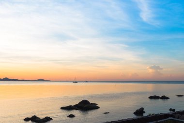 Güzel gün doğumu ve batımı mavi ufukta bulutlar mavi deniz ve dağ arka plan sabah ve akşam kes. Yaz aylarında Altın ışık ile doğal deniz manzarası.