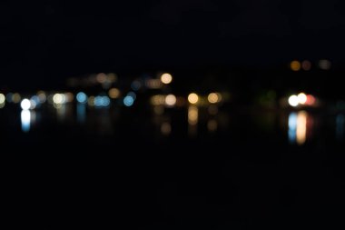 Geceleri deniz üzerine yansıtan ışık soyut bokeh.