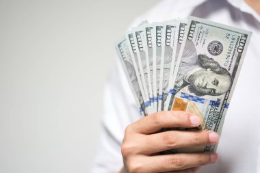 Bizi dolar para beyaz arka plan üzerinde elinde tutan bir iş adamı. Yatırım, mali ve başarılı iş kavramı USD faturaları.