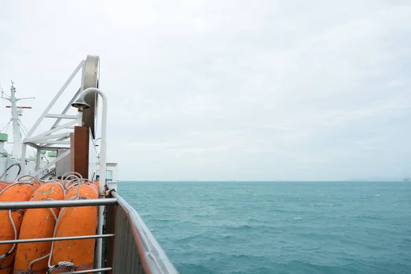 Side view of orange lifeboat steel fence and barrier to prevent passengers falling from boat. Small craft aboard a ship to allow for emergency escape and this boat designed for sea rescues.
