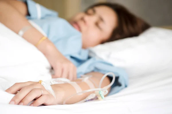 Seçici odak Tuzlu Çözüm intravenöz enjeksiyon tarafından alma kadın hastanın yandan tedavi sıvı replasman tedavisi hastanede VIP odasında olun. Tıbbi tedavi, sağlık ve acil hasta bakımı.