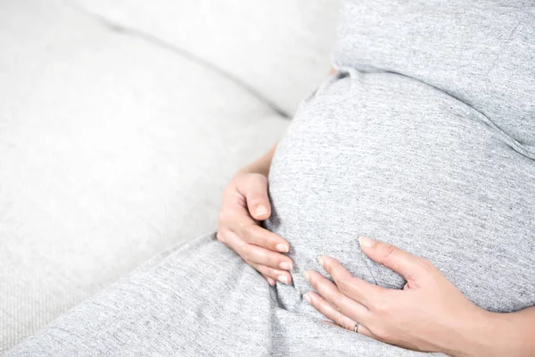 Νέοι Όμορφη Έγκυος Γυναίκα Κάθεται Στο Γκρι Καναπέ Στο Σπίτι — Φωτογραφία Αρχείου