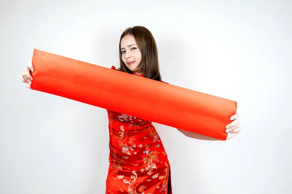 Beauty asian woman wearing cheongsam holding and show blank red couplet spread out of red color paper on hand in Happy Chinese New Year festive and celebration, isolated on white background.