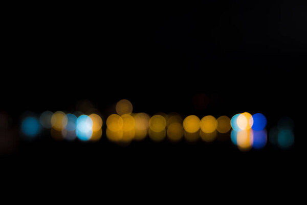 Abstract bokeh from light reflecting over sea at night.
