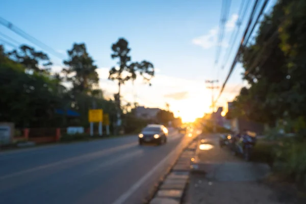 Blurred of urban road in sunset after rain with car on road. Use for traffic background concept.