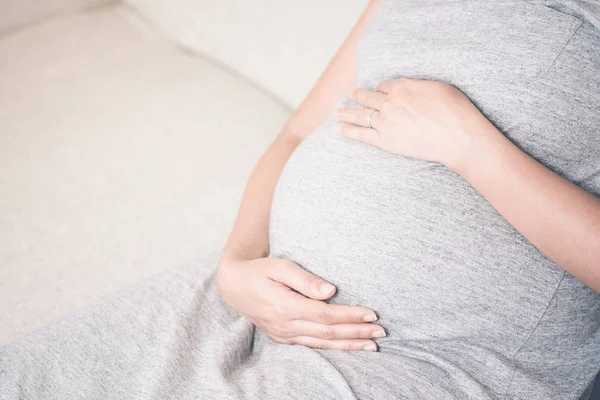 Zbliżenie Dłoni Młoda Piękna Kobieta Ciąży Dotykając Jej Brzuch Siedząc — Zdjęcie stockowe