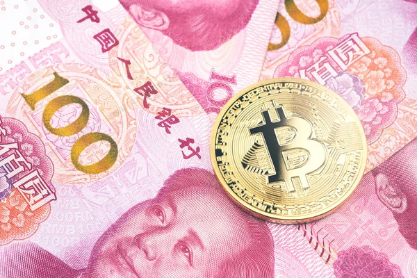 Altın bitcoin yüz Çin yuan banknotların arka plan yığını üzerinde. Cryptocurrency, dijital para yuan para faturaları ile.
