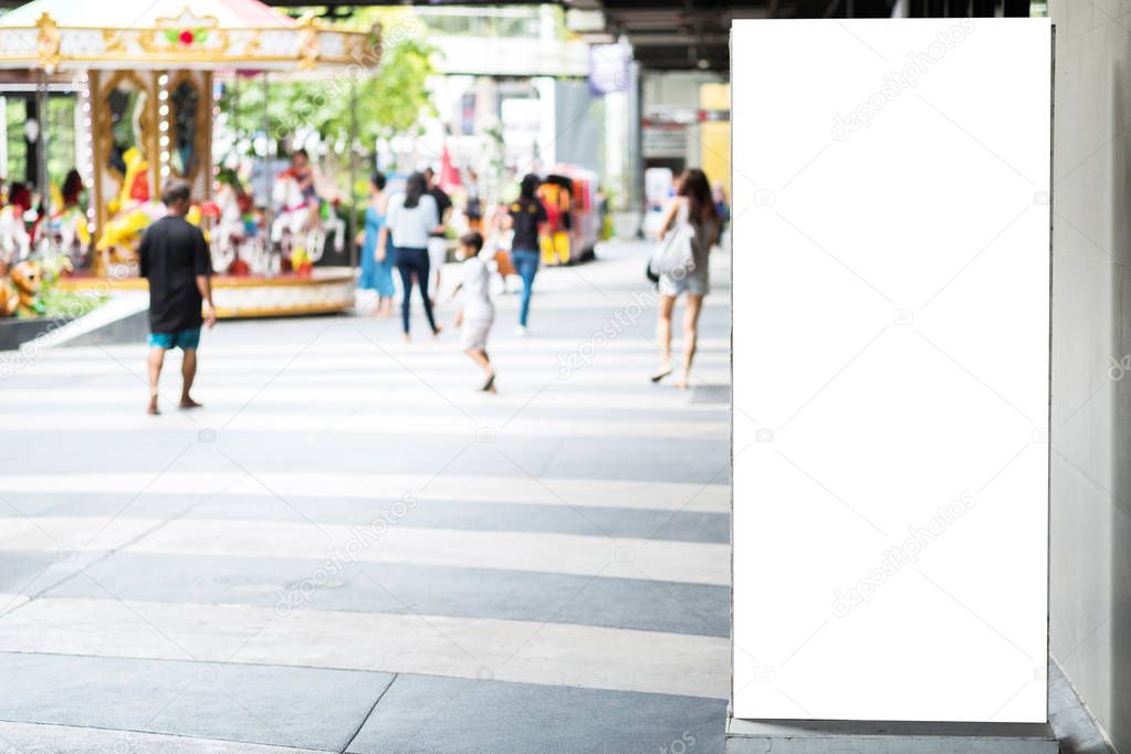 Blank advertising billboard with copy space for text, image and content at open air shopping mall with blurred background people walking and kids play ground. Mock up empty poster and banner display.