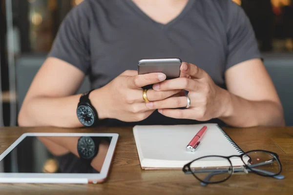 Jovem Usando Smartphone Enquanto Senta Mesa Madeira Com Tablet Digital — Fotografia de Stock