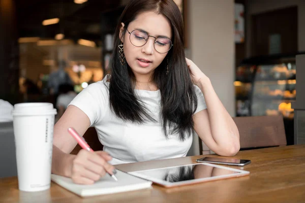Asiatische Geschäftsfrau Mit Brille Die Notizbuch Schreibt Während Sie Mit — Stockfoto