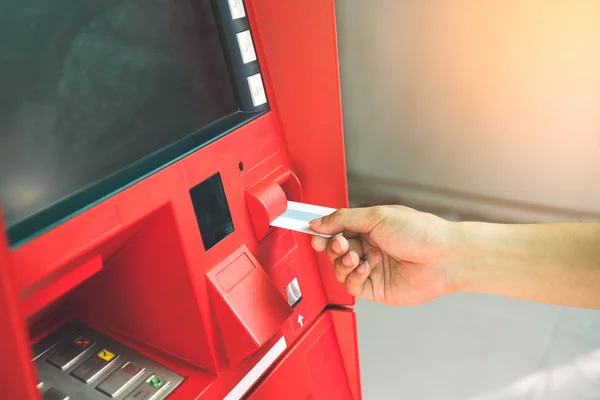 male hand inserting credit card in  ATM machine with blank white screen to withdraw money. Banking and financial concept