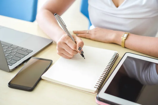 若い女子学生コンテンツの執筆 教育の概念 デジタル タブレット スマート フォン 自宅でノート パソコン テーブルに坐っている間ノートに書く — ストック写真