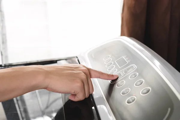 洗衣机中的男性手选择程序和按下启动按钮 — 图库照片