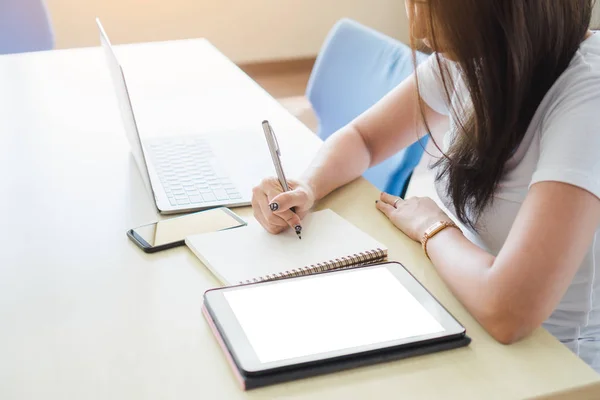 Asiática Estudante Escrevendo Notebook Enquanto Sentado Mesa Com Laptop Tablet — Fotografia de Stock