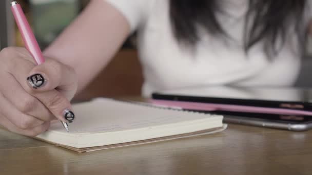 Közelről nő kézi írás ötlet, és tartalom-notebook-tollal a fából készült asztal tabletta, smartphone, kávézó. 