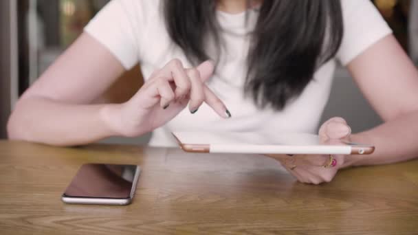クローズ アップ若いアジア女性カジュアルなデジタルを使用してタブレットのカフェに座っている間オンライン ニュースとメールを読んで — ストック動画