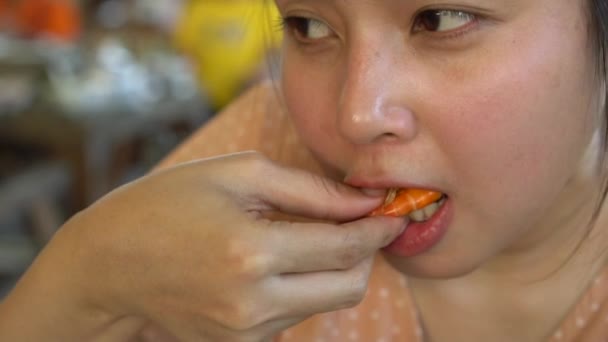 スローモーション若いアジア女性がレストランで焼きエビを食べています — ストック動画