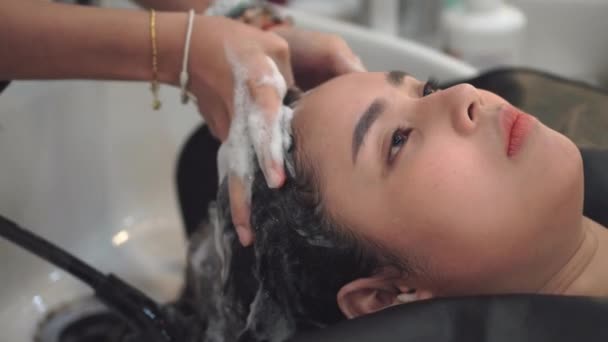 Szczęśliwa Młoda Kobieta Azjatyckich Fryzjerski Aplikowania Szamponu Masuje Włosy Salonie — Wideo stockowe