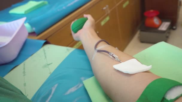 Don de sang. Main masculine du donneur de sang et boule de caoutchouc serrant pour cogner le sang pendant la procédure de collecte de sang veineux à l'hôpital. Soins de santé et soins médicaux .