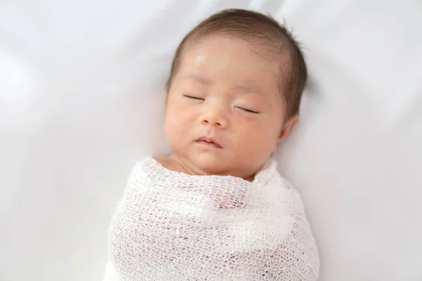 Bebê recém-nascido adormecido em envoltório branco, enquanto no cobertor branco backg — Fotografia de Stock