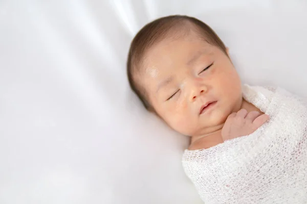 Bebê recém-nascido adormecido em envoltório branco, enquanto no cobertor branco backg — Fotografia de Stock