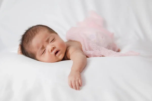 Rozkošné asijské novorozence v růžovém zábalu spící na bílém prázdném — Stock fotografie