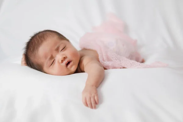 Adorável asiático recém-nascido bebê em rosa envoltório dormindo em branco — Fotografia de Stock