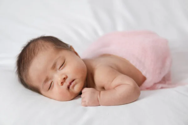 Adorável asiático recém-nascido bebê em rosa envoltório dormindo em branco — Fotografia de Stock