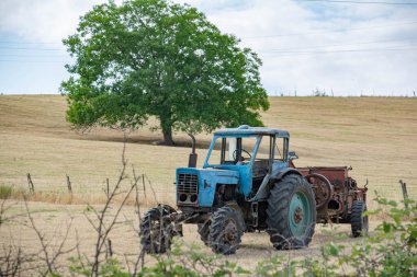 Çiftçi mavi traktörünü tarlada bıraktı.