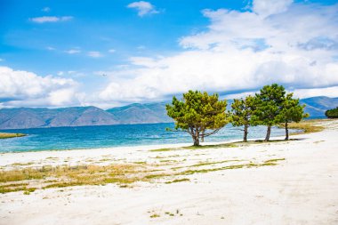 Güneş, mavi deniz ve beyaz kum