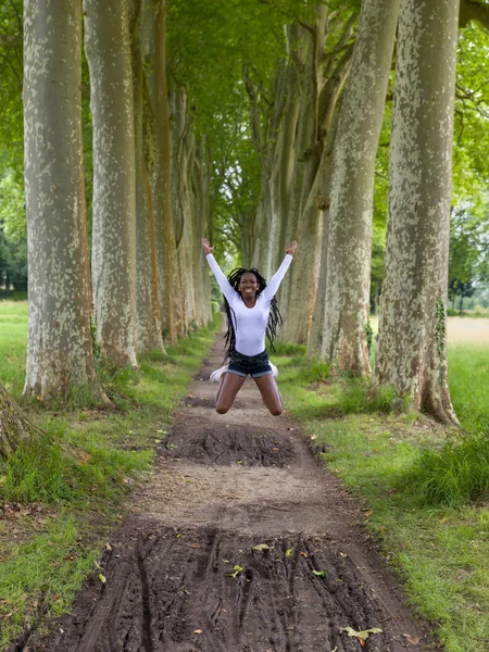 Mulher pulando no campo — Fotografia de Stock