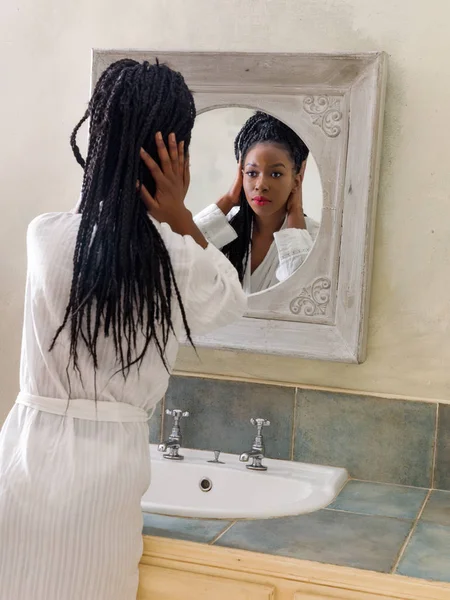 Mulher com cabelo afro olhando no espelho — Fotografia de Stock