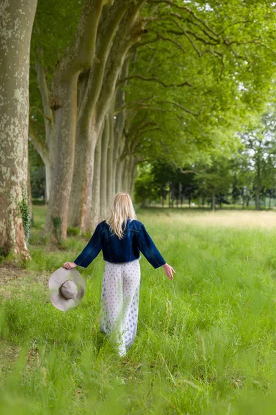 Mulher loira andando na floresta — Fotografia de Stock