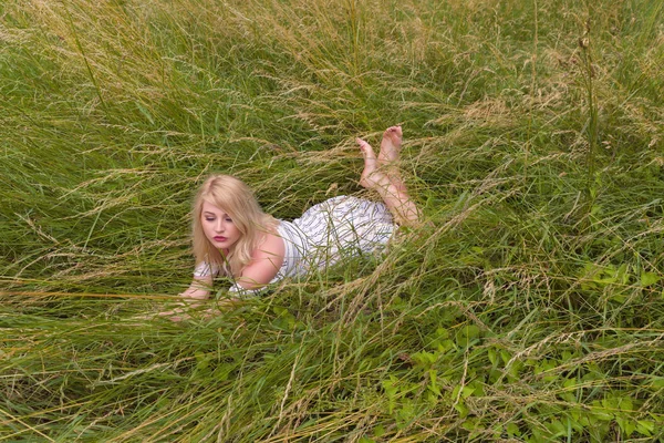 Vacker blondin i gröna gräs — Stockfoto