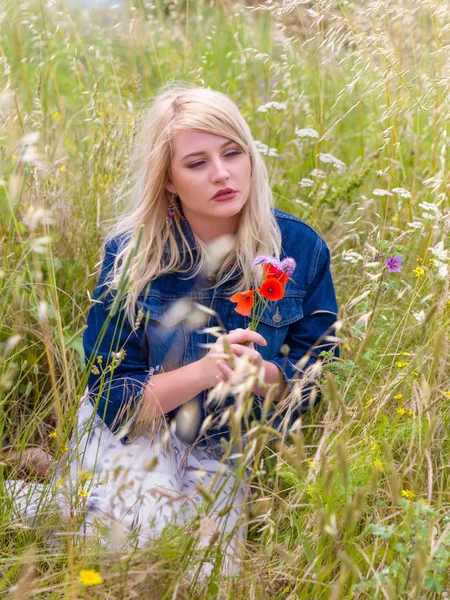 Красивая блондинка с полевыми цветами — стоковое фото