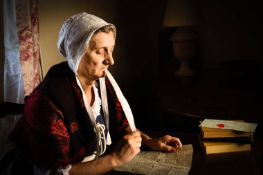 Rembrandt tarzı ya da Rönesans portresi tüy kalemiyle mektup yazan bir kadın.