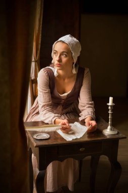Vermeer tarzı, Rönesans kostümlü genç bir kızın tüy kalemiyle bir mektup yazması.