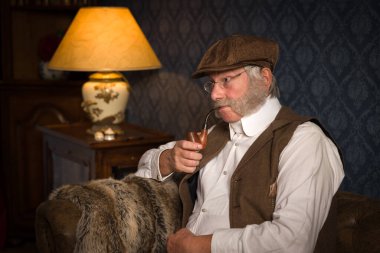 Viktorya dönemi kıdemli bir beyefendinin piposunu içişi.