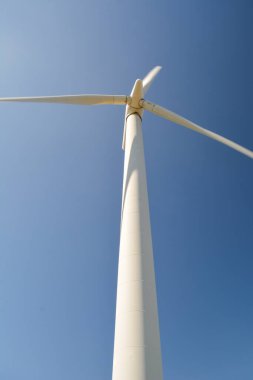 Yenilenebilir ve düşük karbon enerjisi üreten rüzgar türbininin dönen bıçaklarının yakın ve düşük açılı görüntüsü