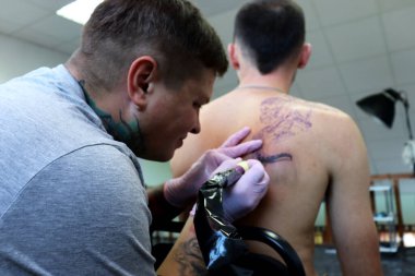 Erkek teninde çok güzel bir dövme. Dövmeci iş başında. Profesyonel iş.