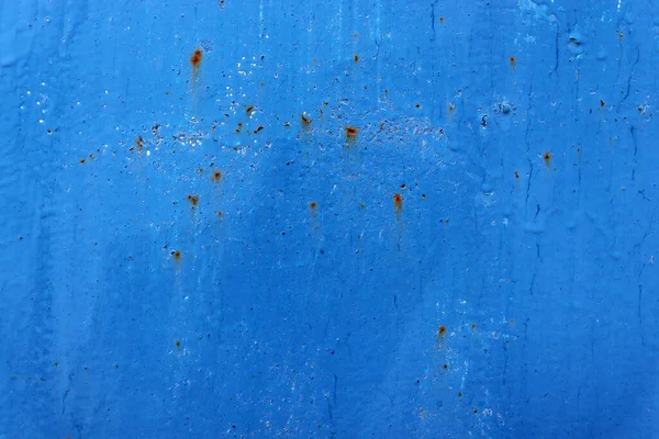 Beautiful old blue paint on wall surface. Abstract blue wall texture with cracks and rusty