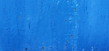 Matal duvar yüzeyinde güzel, eski, mavi çizikler var.