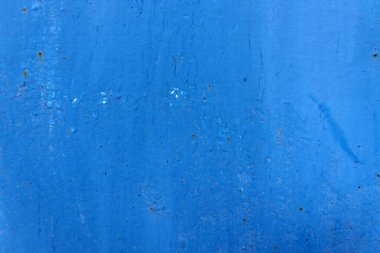 Çatlak demir duvarda eski mavi çizikler var. Mavi doku arkaplanı