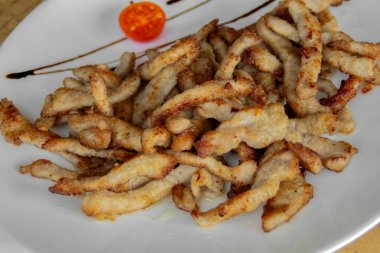 Çıtır kızarmış domuz dilimleri. Kiraz domates ve Balsamik Sos ile süslenmiş. Closeup.