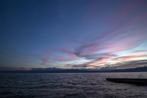 Colors after sunset dance in the sky. Landscape of Ohrid Lake.