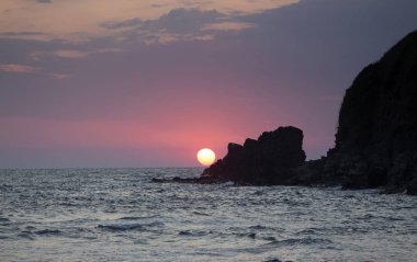 Güneş kayanın üzerinde doğar. Sinemorets tatil beldesinden görünüm, Güney Karadeniz Kıyısı, Bulgaristan.