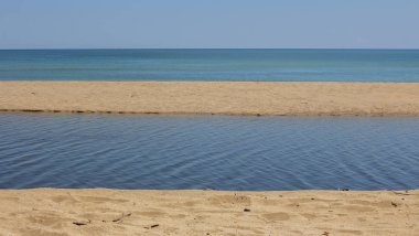 Doğanın uyumu - kum, nehir, deniz ve gökyüzü. Ağustos'ta Kamchia Nehri'nin ağzında. Bulgaristan.