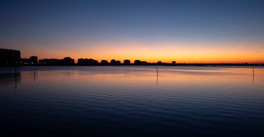 Gün batımından sonra deniz kenarındaki bir tatil köyünde bir dizi tuz gölü manzarası. Güneşin kaybolduktan sonra bıraktığı sihirli ışık. Pomorie tatil beldesi, Bulgaristan.