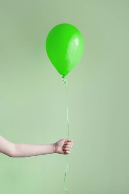 el tek yeşil balon tutarak